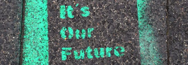 A spray-painted sign on cement that reads "It's our future."