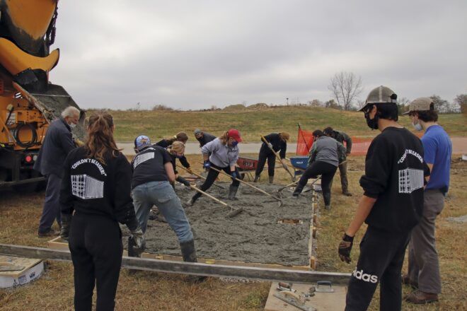 A team laying the foundation for a tiny home.