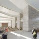People walking through the lobby of an office building with white walls and floors and columns.