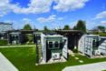 A green courtyard full of shipping container homes.