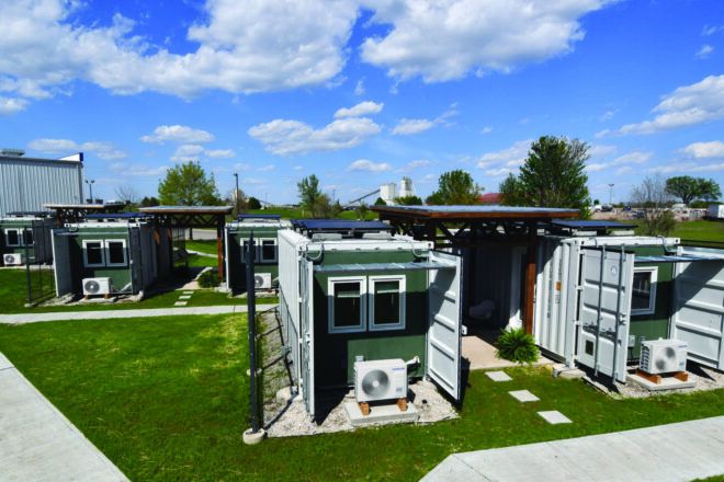 A green courtyard full of shipping container homes.