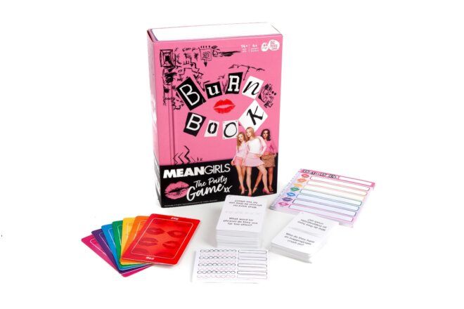 A pink game box titled "Burn Book," with game pieces arranged in front of it.