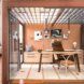 An office space with a wood frame and glass walls that look into a room with a desk and chair.