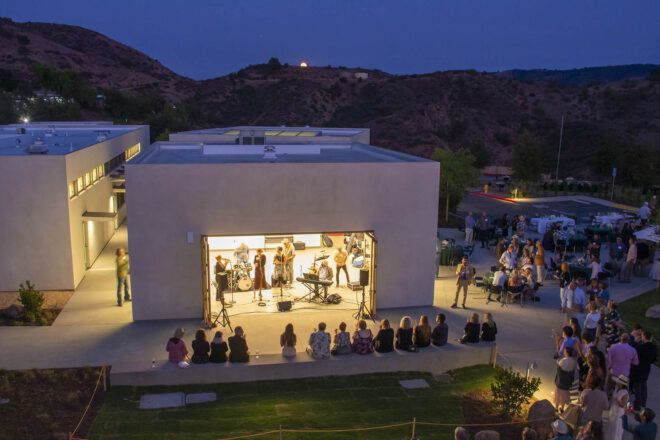 A campus building lit up at dusk.