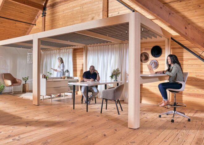 Three people working in an office space completely made of wood.