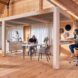 Three people working in an office space completely made of wood.