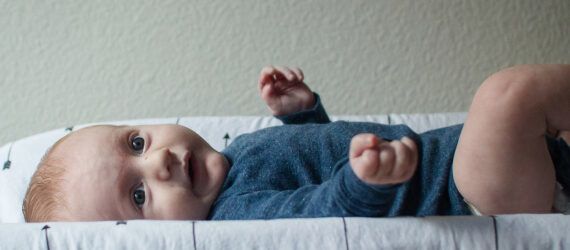 A baby laying on a changing table.