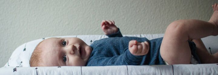 A baby laying on a changing table.