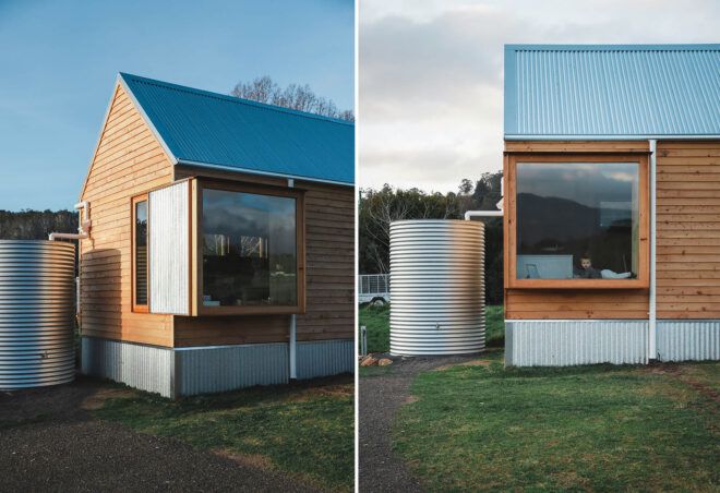 To the left, a diagonal view of a simple wood house with a large window and steel water tank. To the left, a side view of a simple wood house with a large window and steel water tank. In the large window, you can see a child laying down.