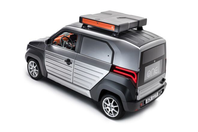 The back of a black and silver car with roof rack.
