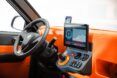 The front wheel of a car with an orange dashboard.