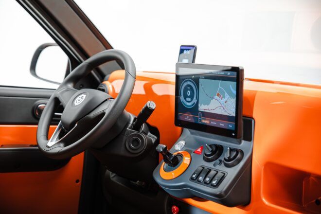 The front wheel of a car with an orange dashboard.
