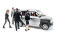 A group of people standing around a car.