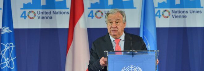 U.N. Secretary-General Antonio Guterres standing at a blue podium.