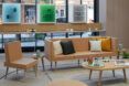 A beige sofa, end table and coffee table in the middle of a retail space.