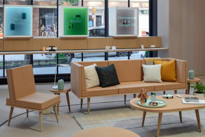 A beige sofa, end table and coffee table in the middle of a retail space.