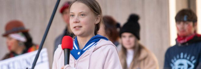 Greta Thunberg holding a microphone.