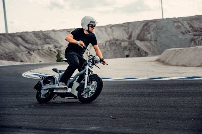 A person wearing a helmet and driving an electric moped.