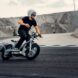 A person wearing a helmet and driving an electric moped.