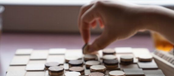 A person playing a wooden board game.