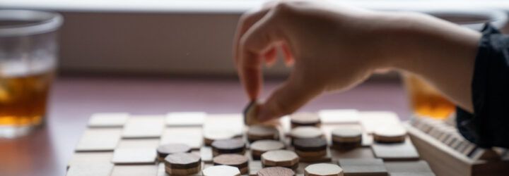 A person playing a wooden board game.