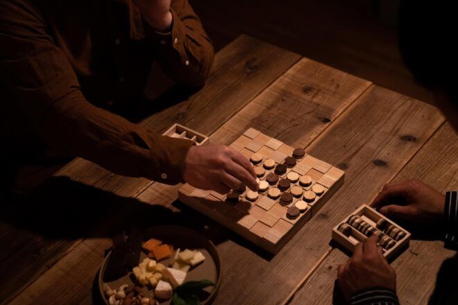 An overhead view of a person playing a wooden board game.
