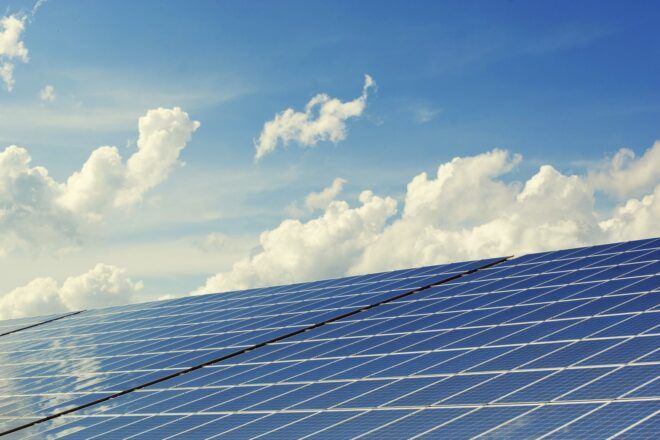 Solar panels against a cloudy sky.