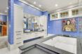 A bathroom with blue walls and white counters.
