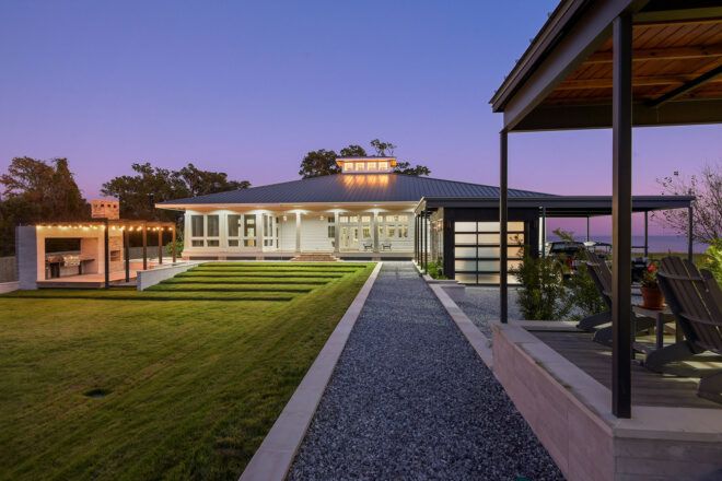 A walkway leading up to a lit up home.