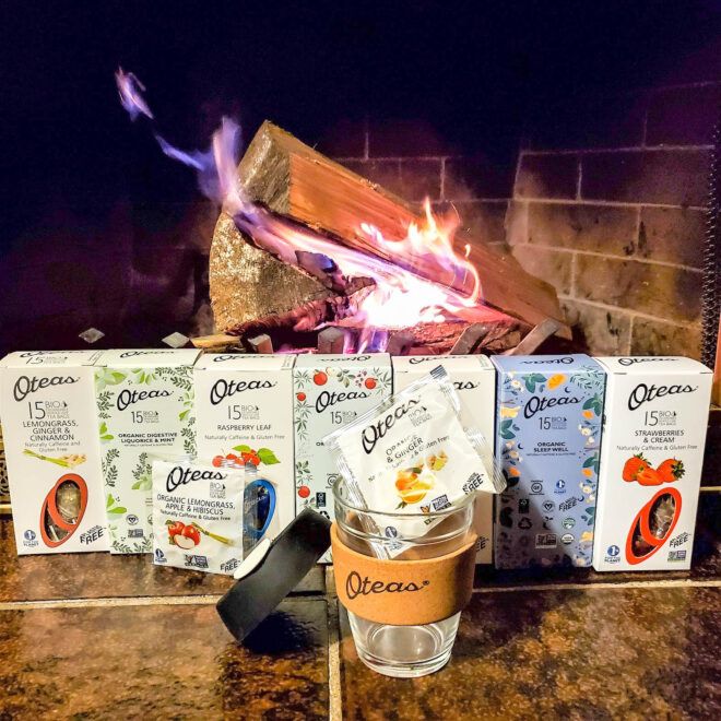 A row of Oteas packages with a Oteas branded mug in front of it