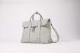 A grey bag sitting against a blank white background