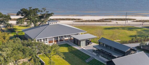 An aerial view of a beach home by the coast.