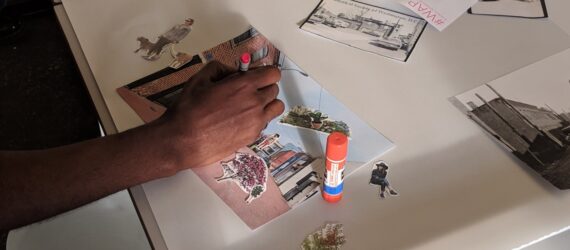 A person working on a collage at a craft table.