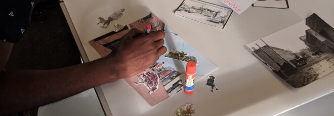 A person working on a collage at a craft table.