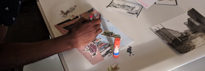 A person working on a collage at a craft table.
