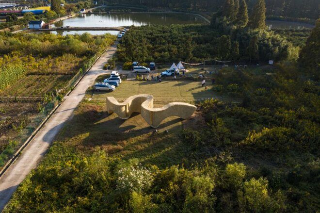 A semi-aerial view of the pavilion in a field.