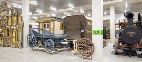 Room filled with historical cars and vehicles