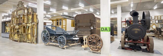 Room filled with historical cars and vehicles