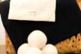 Laundry hamper with a stack of dryer balls in front