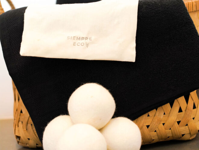 Laundry hamper with a stack of dryer balls in front