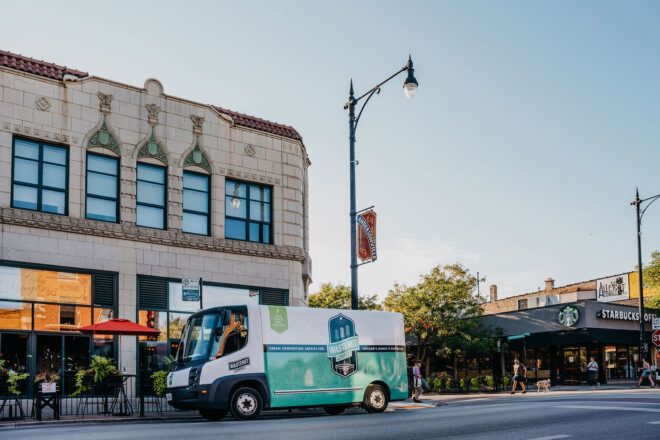 A street with a green truck parked.