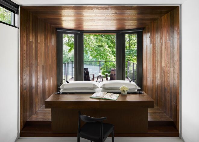 A wooden desk inside a brown-walled room that faces an open window
