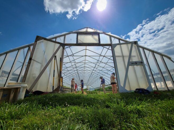 Open greenhouse door with students inside