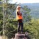 A woman standing on a stump of wood