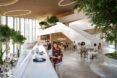 A two-level sitting and dining area full of people.