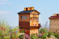 A Flow Pollinator House surrounded by flowers.