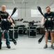 Two men holding drones that cover almost their entire height