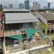 An aerial view a house with a semi-covered parking area.