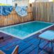 A pool enclosed by a wood fence.