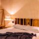 A bedroom with a white bed and gray blanket.